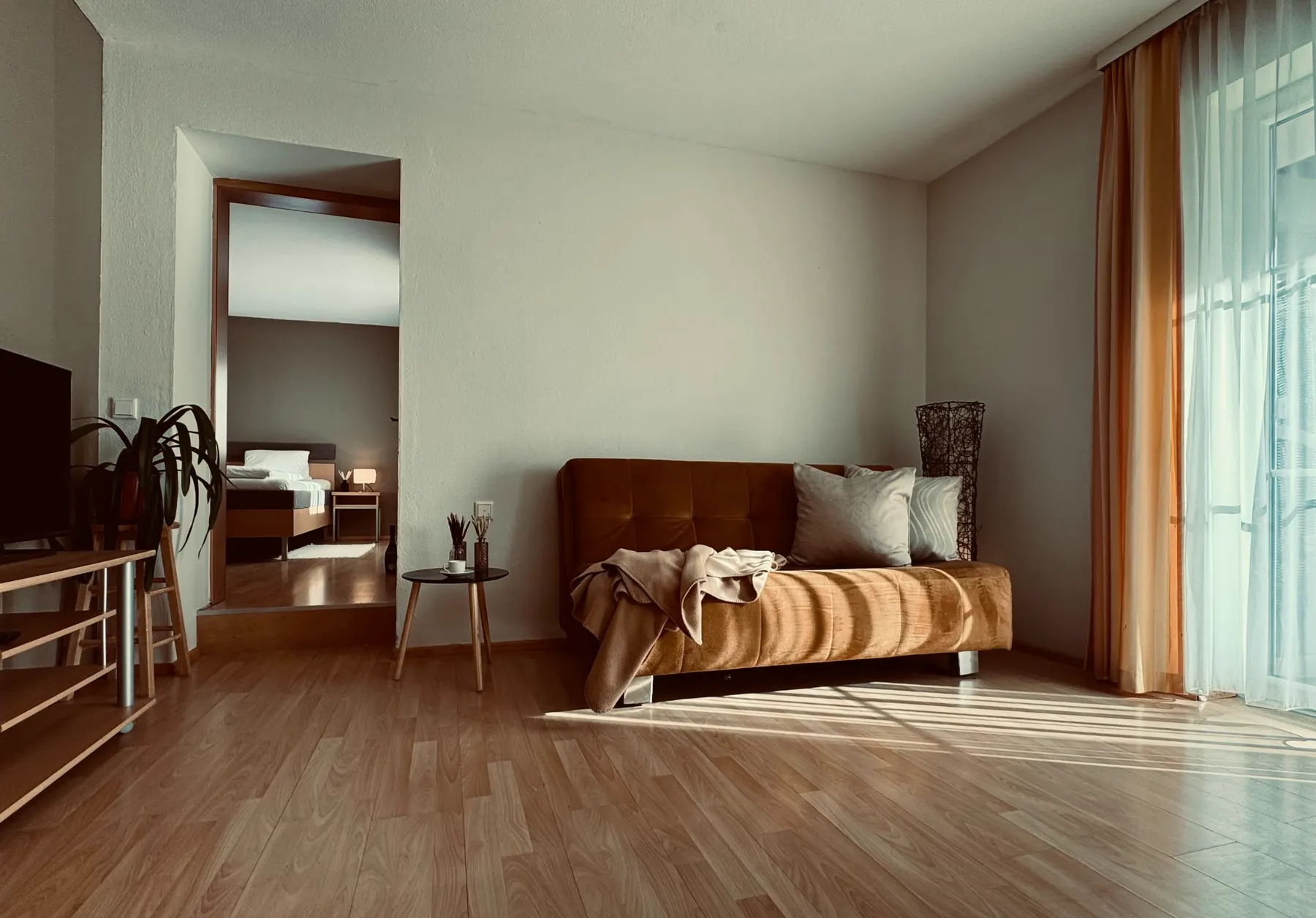 Living room with sofa and a view into the bedroom