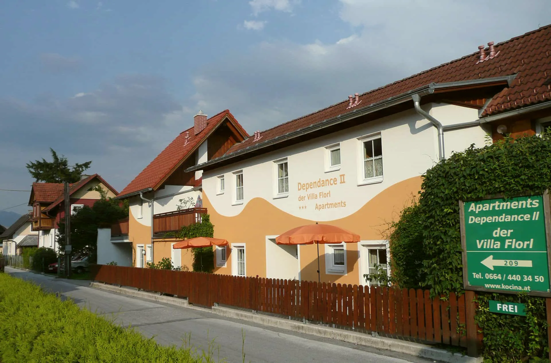 Dependance II of Villa Florl with parasols and wooden fence